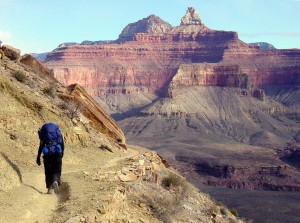 A HIKER ON THE SOUTH KAIBAB TRAIL ABOUT HALF-WAY TO PHANTOM RANCH. ZOROASTER AND BRAHMA TEMPLES BEYOND. GRAND CANYON NATIONAL PARK.